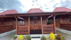 a wooden house with a gate and some flowers at Katah Montana Villa in Tonoboyo