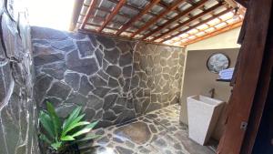 a bathroom with a stone wall and a shower at Katah Montana Villa in Tonoboyo