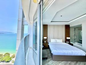 a bedroom with a bed and a balcony with the ocean at Panorama Ocean View Luxury Apartment Nha Trang in Nha Trang +55 photos