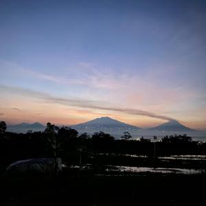 a view of a mountain with a sunset in the background at Katah Montana Villa in Tonoboyo +5 photos