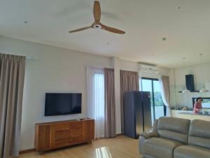 a living room with a couch and a flat screen tv at Patra Phuket Private Residence in Ban Nong Chaeng