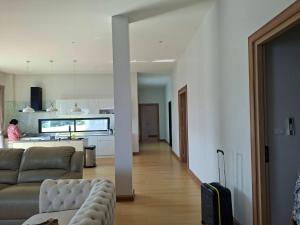 a living room with a couch and a kitchen at Patra Phuket Private Residence in Ban Nong Chaeng