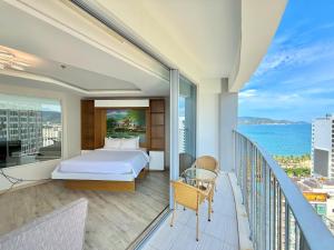 a bedroom with a bed and a balcony with the ocean at Panorama Ocean View Luxury Apartment Nha Trang in Nha Trang