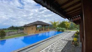 a swimming pool with a gazebo next to a house at Katah Montana Villa in Tonoboyo