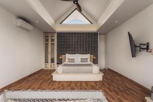 a bedroom with a bed and a skylight at Astera Resort & Spa Canggu by Ini Vie Hospitality in Canggu
