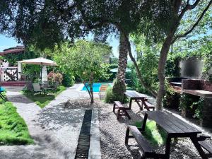 a picnic table and benches in a yard with a pool at Hostal White beach in Paraguchi +27 photos