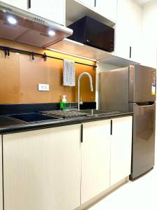 a kitchen with a sink and a stainless steel appliance at Modern Stays Makati Pool View Jazz Residences in Manila +8 photos
