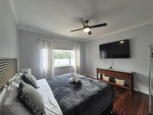 a bedroom with a bed and a flat screen tv at Dempster House in Esperance