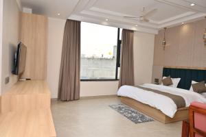 a bedroom with a large bed and a large window at Hotel The Sabhyansh in Khātu