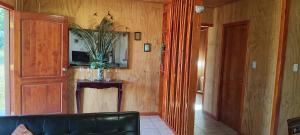 a living room with a black couch and a mirror at Cabaña La Ondina in Melipeuco
