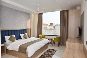 a bedroom with a bed and a desk and a window at Hotel The Sabhyansh in Khātu +130 photos