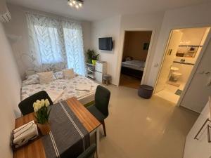a bedroom with a bed and a table and a room at Bamboo Wellness Apartment in Siófok