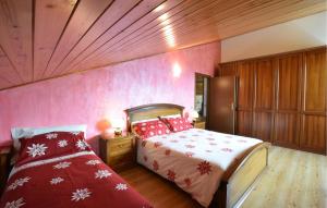 a bedroom with a bed with red pillows on it at Awesome Apartment In Sovramonte With Wifi in Sovramonte