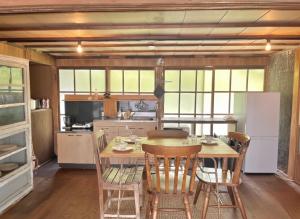 a kitchen with a table and chairs and a refrigerator at 古民家ステイshinonome inn in Kitsuki