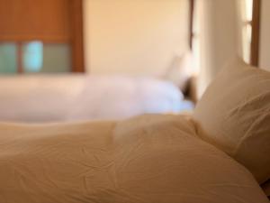 a close up of a bed in a bedroom at 古民家ステイshinonome inn in Kitsuki