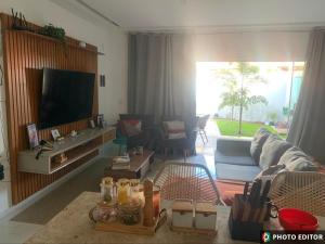 a living room with a couch and a flat screen tv at Casa Cristã Familiar JR in Paracuru