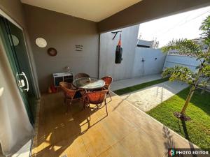 a patio with a table and chairs on a porch at Casa Cristã Familiar JR in Paracuru