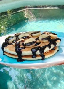 a donut on a plate next to a pool of water at Kai's Beachfront Villa in Gili Islands +75 photos