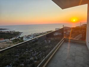 a balcony with a view of the ocean at sunset at Vila SOL DEL MAR in Utjeha