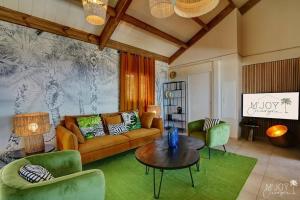 a living room with a couch and a table and chairs at Villa Austral et Lagons in Étang-Salé