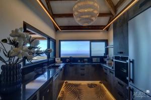 a kitchen with a large counter with a large window at Villa Austral et Lagons in Étang-Salé +23 photos