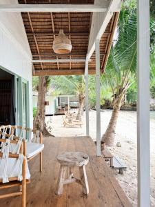 a porch with chairs and a table and a bench at The Angkayo in Angkayo
