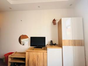 a living room with a tv and a refrigerator at Hoa Viên Hotel in Hòa Ðình +2 photos