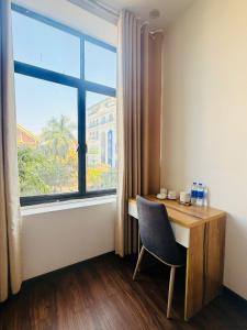 a desk with a chair next to a large window at Hoa Viên Hotel in Hòa Ðình