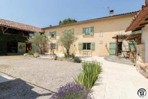 a house with a courtyard in front of it at La ferme in Ponlat-Taillebourg