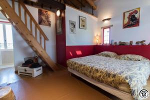 a bedroom with a bed and a red and white wall at La ferme in Ponlat-Taillebourg