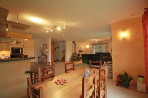 a kitchen and living room with a table and chairs at Le pin parasol in Arnac-la-Poste