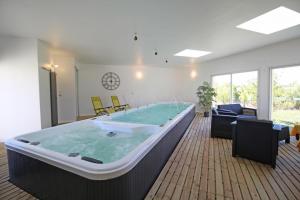 a large hot tub in a living room with furniture at Le pin parasol in Arnac-la-Poste