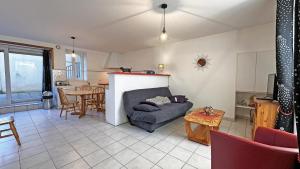 a living room with a couch and a table at Le gîte communal in Dompierre-les-Églises