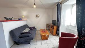 a living room with a couch and a table at Le gîte communal in Dompierre-les-Églises