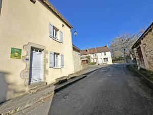 an empty street next to a building with a blue door at Le gîte communal in Dompierre-les-Églises