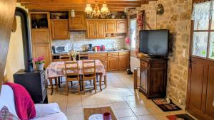 a kitchen with a table and a tv in a room at La rivaille in Lussac-les-Églises
