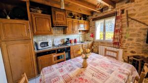 a kitchen with a table with a table cloth on it at La rivaille in Lussac-les-Églises