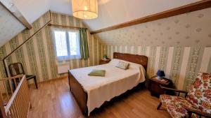 a bedroom with a bed and a chair at La rivaille in Lussac-les-Églises