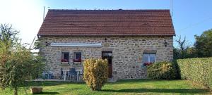 a stone house with a red roof on a yard at La rivaille in Lussac-les-Églises +15 photos