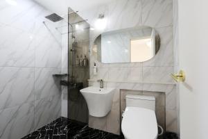 ein Badezimmer mit Toilette, Waschbecken und Spiegel in der Unterkunft 호텔 더블랙 in Hwangsan-do + 53 Fotos
