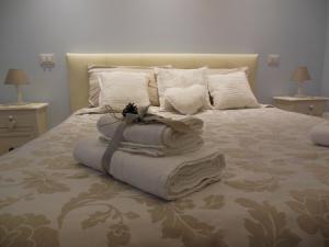 - un grand lit avec des serviettes et des oreillers dans l'établissement La Cupola Suite, à Rome