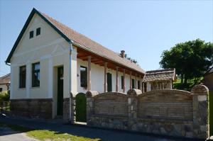 a house with a brick fence in front of it at Zengőalja Vendégház in Erzsébet +19 photos