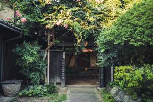 an open door into a garden with trees and flowers at Shirafuji in Suzaka