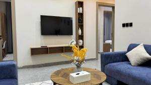 a living room with two blue couches and a tv at شقق العامر in Jeddah