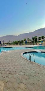 a swimming pool with blue water and mountains in the background at Porto El Sokhna in Ain Sokhna