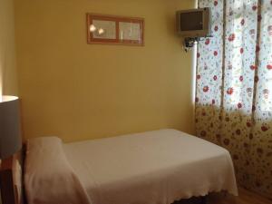 a small room with a bed and a window at Pensión Galatea in O Vicedo