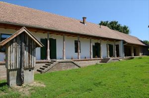 a building with a grass field in front of it at Zengőalja Vendégház in Erzsébet