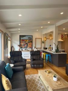 a living room with a couch and a table at Lake Views, Ani Miria Place, Te Rangiita, Turangi in Turangi