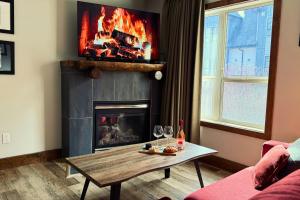 a living room with a fireplace and a table with wine glasses at Spacious, Pet Friendly, Townhouse Hot Tub Perfect for Families! in Canmore +14 photos
