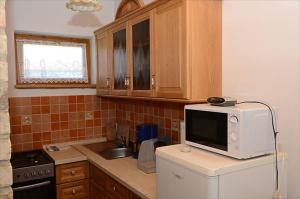 a kitchen with a microwave on top of a refrigerator at Zengőalja Vendégház in Erzsébet